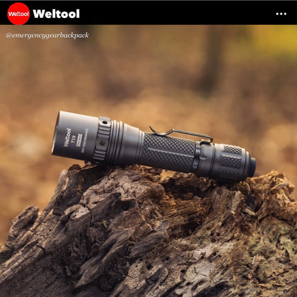 Weltool T19  flashlight on a wooden log with Weltool branding.