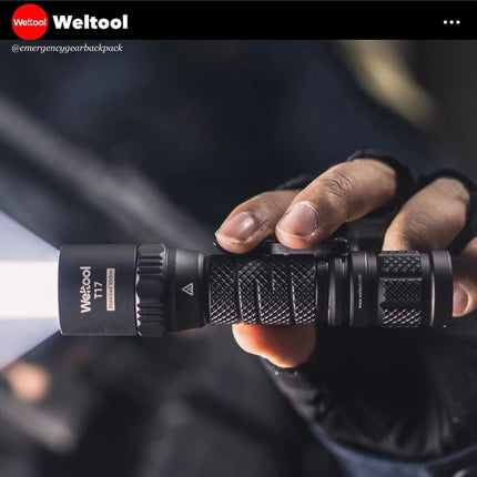 Hand holding Weltool T17 flashlight, compact and portable.