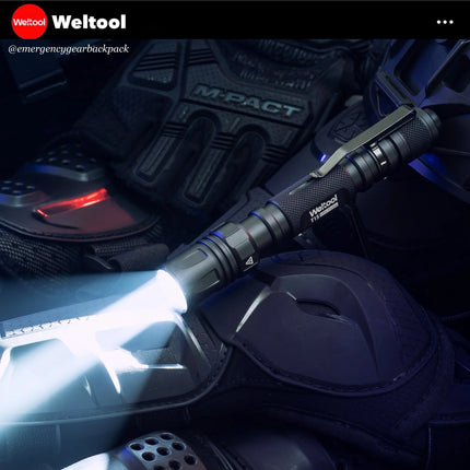 Weltool flashlight on a dark background with tactical gear