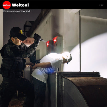 Two individuals in tactical gear with a flashlight in a dark setting, likely an emergency scenario.