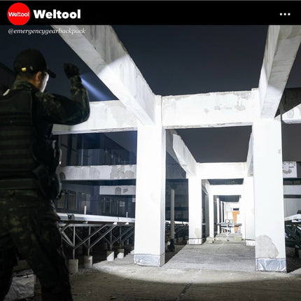 Person using a flashlight in a dark industrial area with Weltool branding.