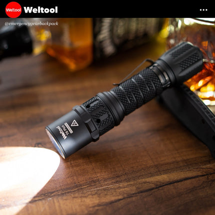 Weltool T8Plus flashlight on a wooden surface with blurred background